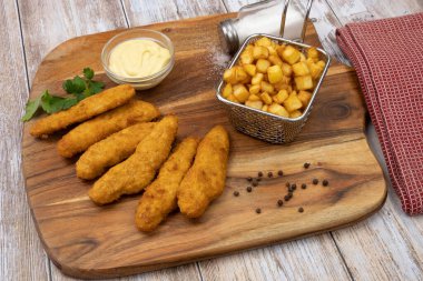 Sos ve patates kızartmasıyla kızartılmış kızarmış tavuk şeritleri. 