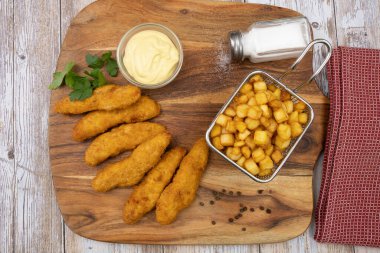 Sos ve patates kızartmasıyla kızartılmış kızarmış tavuk şeritleri. 