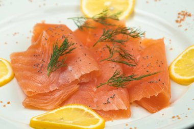 Bir tabakta füme somon ve limon dilimleri