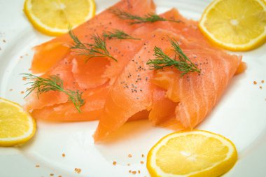 Bir tabakta füme somon ve limon dilimleri