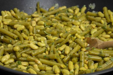 Tahta masadaki tavada haşlanmış yeşil fasulye. 