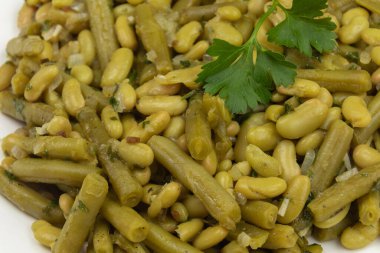 Beyaz tabakta haşlanmış yeşil fasulye. 