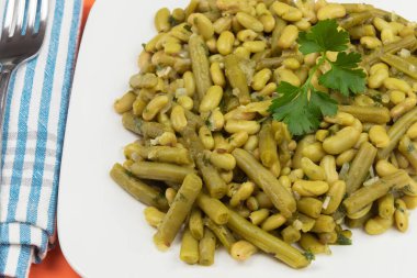 Beyaz tabakta haşlanmış yeşil fasulye. 