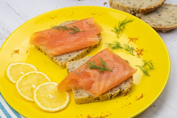 Sarı tabakta füme somon tostu.