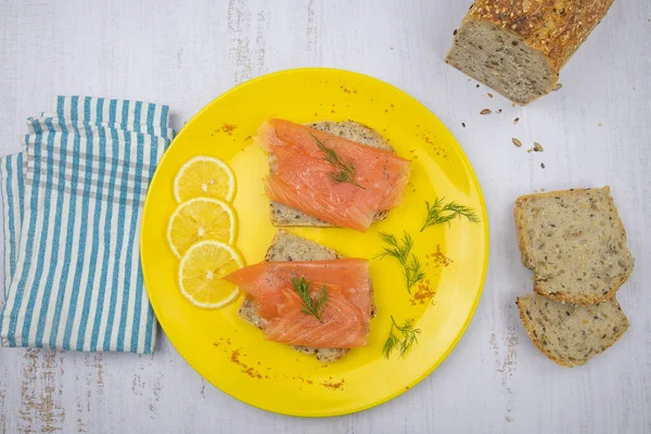 Sarı tabakta füme somon tostu.