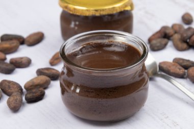 Masadaki küçük cam çikolata kavanozu.