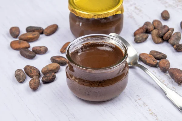 Masadaki küçük cam çikolata kavanozu.