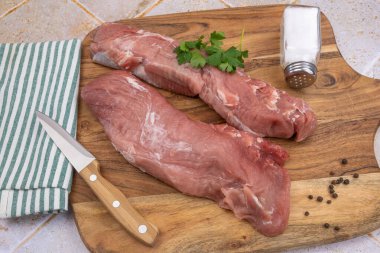 Kesme tahtasındaki çiğ domuz filetosu.