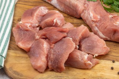 Kesme tahtasındaki çiğ domuz parçaları.