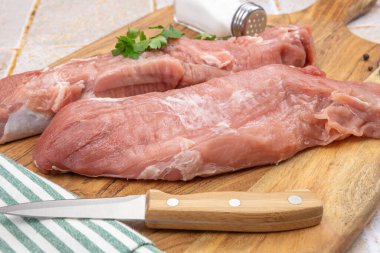 Kesme tahtasındaki çiğ domuz filetosu.