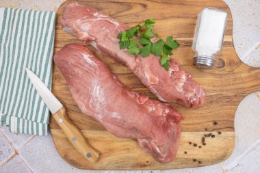 Kesme tahtasındaki çiğ domuz filetosu.