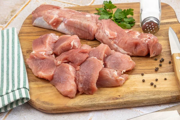 Kesme tahtasındaki çiğ domuz parçaları.