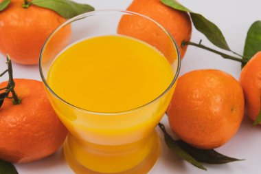 Taze portakal suyu ve yapraklı mandalinalar 