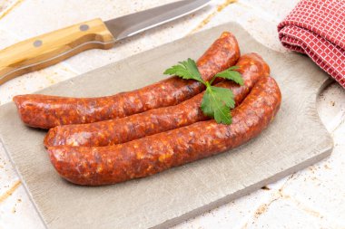 Kesme tahtasındaki birkaç çiğ merguez.