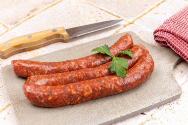 Kesme tahtasındaki birkaç çiğ merguez.