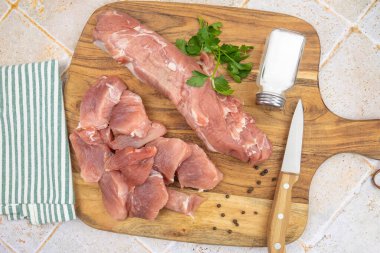 Kesme tahtasındaki çiğ domuz filetosu.
