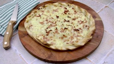 Flammekueche (alevli turta), kesim tahtasındaki Alsas spesiyali.