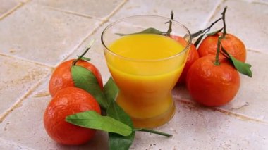 Taze portakal suyu ve yapraklı mandalinalar 