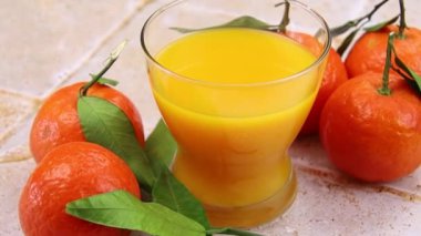 Taze portakal suyu ve yapraklı mandalinalar 