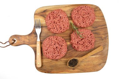 Kesme tahtasında birkaç çiğ hamburger.