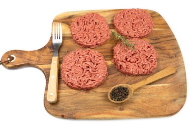 Kesme tahtasında birkaç çiğ hamburger.
