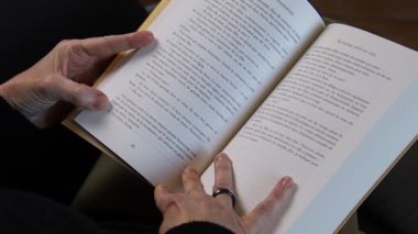 Kadın oturuyordu, bir kitap okuma