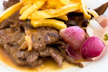 Kızarmış domuz bifteği, patates ve soğanlı.