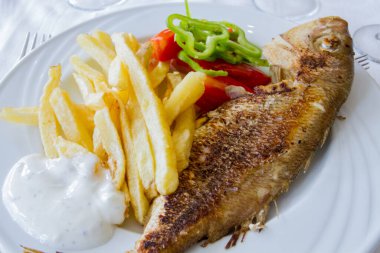 Taze sebzeli ızgara balık ve patates kızartması.