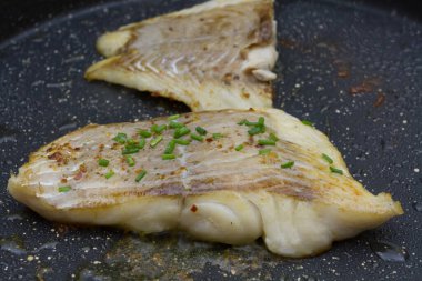 Bitkilerle kızartılmış kömür balığı filetosu. 