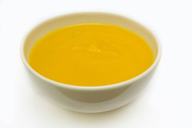 Beyaz arka planda bir kase lezzetli kabak çorbası.