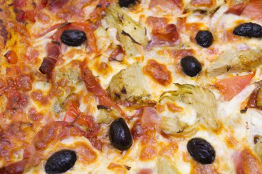 Salamlı, peynirli, zeytinli ve hindibalı pizza. 