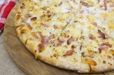 Tahta arka planda jambonlu ve peynirli pizza. 