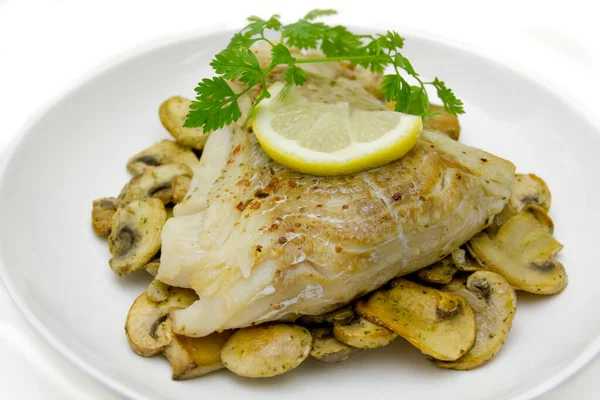 Mantarlı fırında balık, maydanoz ve limon.