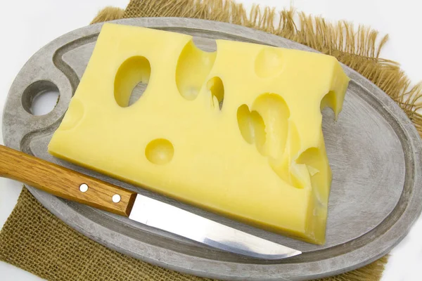 白を基調とした板にナイフでチーズを盛り — ストック写真