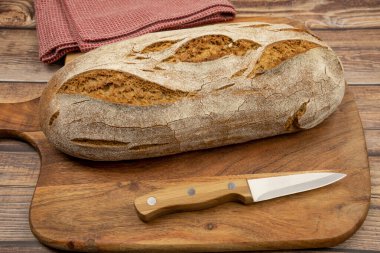 Kesme tahtasının üzerinde bir somun ekmek