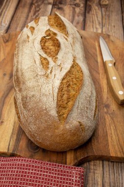 Kesme tahtasının üzerinde bir somun ekmek