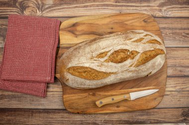 Kesme tahtasının üzerinde bir somun ekmek