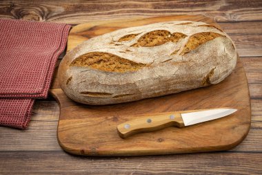 Kesme tahtasının üzerinde bir somun ekmek