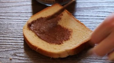 Ekmeğe kakao yağı sürüyorum.
