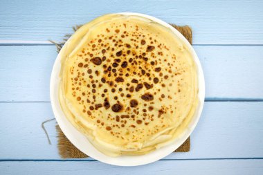 Mavi arka planda bir tabakta gözleme yığını