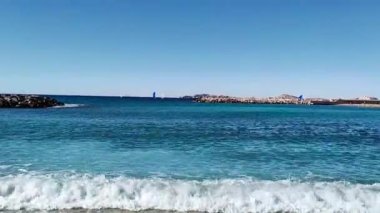 Güneşli bir günde dalgalı ve kayalık sahiller.