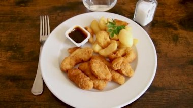 Soslu kızarmış tavuk ve patates kızartması. 