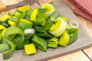 ahşap tahta üzerinde dilimlenmiş pırasa