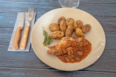 Gri arka planda, tabakta mantar tavşanlı yeni patatesler