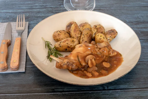 Gri arka planda, tabakta mantar tavşanlı yeni patatesler