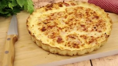Kiş lorraine ahşap bir tahtanın üzerinde pişiyor.