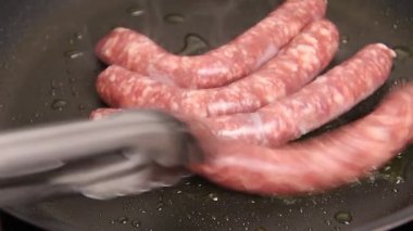 Tavada pişen taze sosisler.