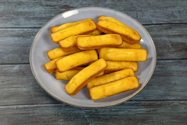 Gri arka planda bir tabakta birkaç madeleine 