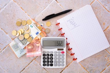 Avro banknot ve hesap makineli sikkeler masanın üzerinde bir defter