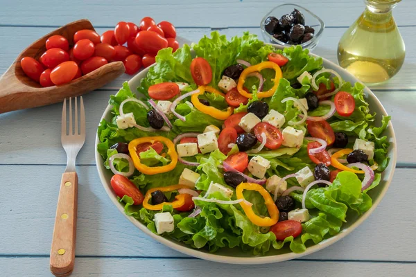 野菜とフェタをテーブルの上の皿に盛ったグリーンサラダ — ストック写真